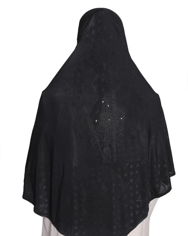 A woman modeling a Black Patterned Embellished Hijab, viewed from the side, highlighting the subtle square pattern and the rhinestone embellishment on the cap area.