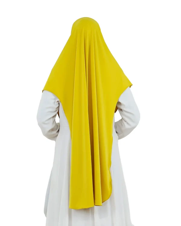A woman models a Radiant Yellow Ribbed Hijab for Women, viewed from the side, emphasizing the texture near the head and the wide, sweeping drape of the yellow fabric.