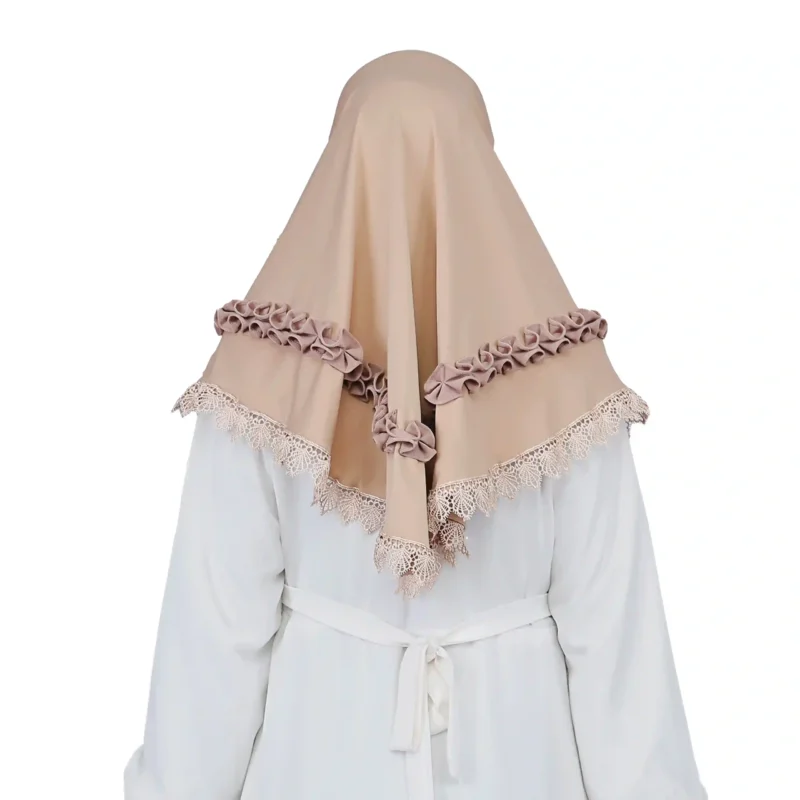 A woman models an Elegant Beige Ruffled and Lace Hijab, viewed from the side, emphasizing the texture of the ruffle details and the graceful flow of the fabric.